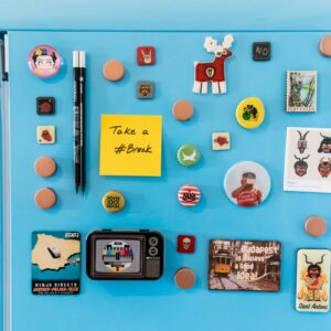 Close up of a blue refrigerator with colourful photo magnets