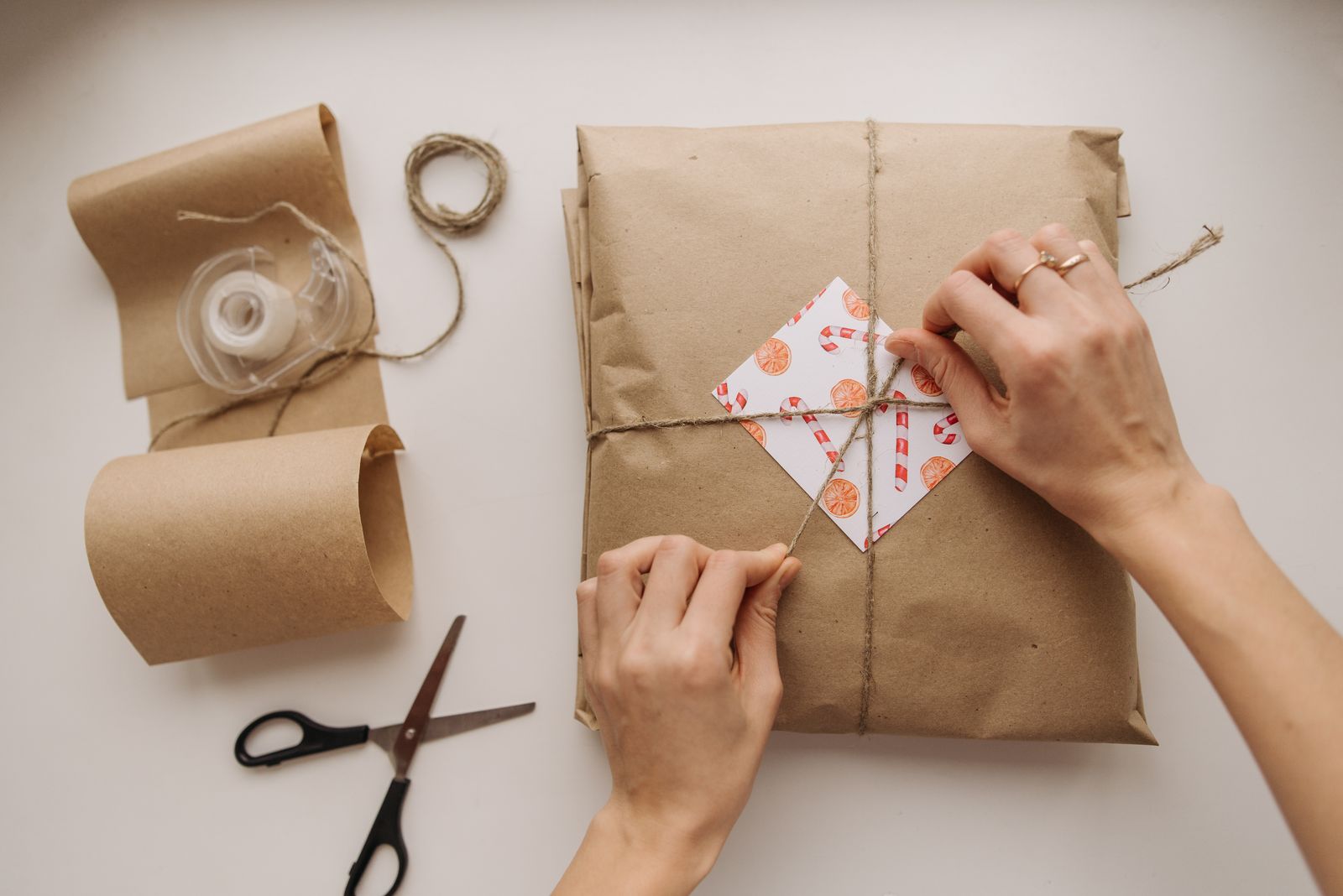 Hands carefully wrapping a package with brown paper